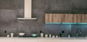Modern kitchen range hood above a stove with cooking pots